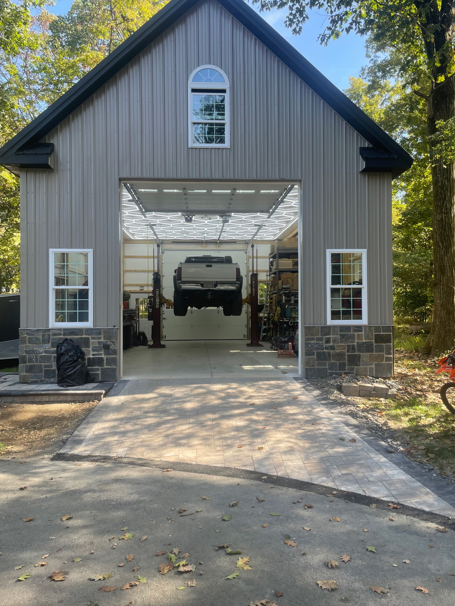 barn sized garage with truck lift and interior lighting, custom barns and garages